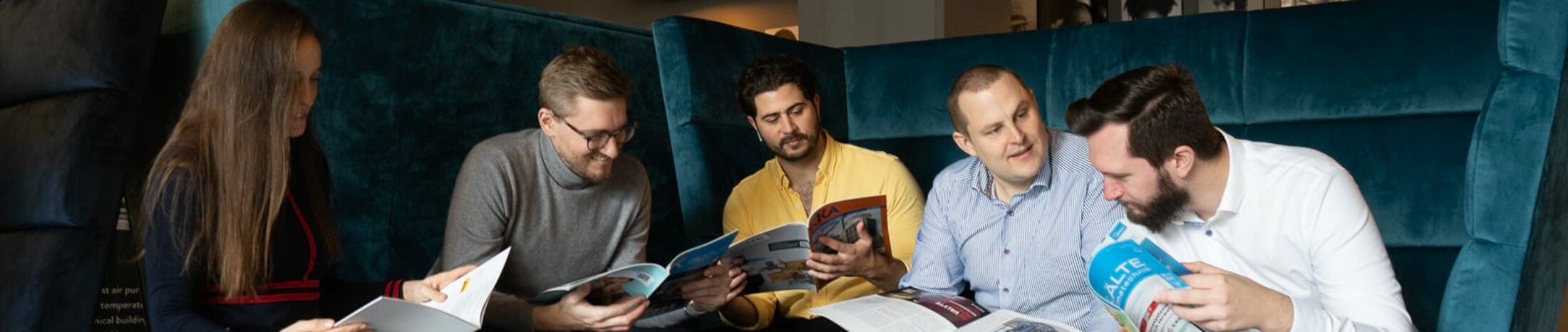 Menschengruppe liest verschiedene Brosch&uuml;ren